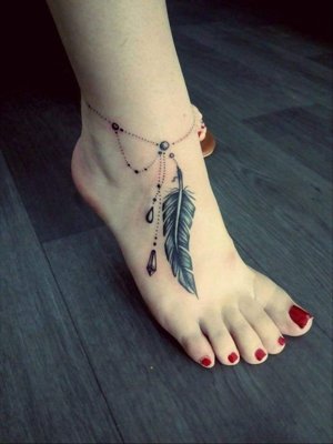Tatouage plume avec une chainette sur la cheville